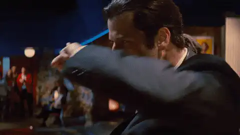 le protag(?) de pulp fiction danse en faisant des peace sign avec les mains