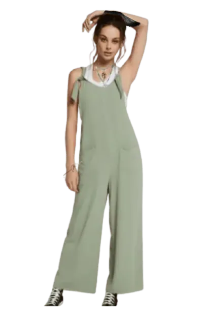 tenue de Nélya : une salopette en tissu souple vert sur débardeur blanc + cheveux attachés en chignon